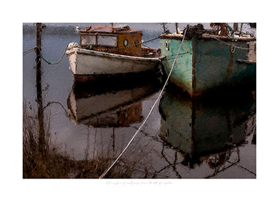 Two old wooden boats painted at mooring.