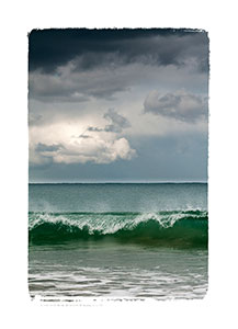 Wave water edge caught falling with background clouds.